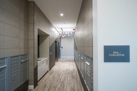A long hallway with a sign that says "Mail / Concierge" on the wall.