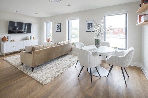 A living room with a couch, chairs, and a television.