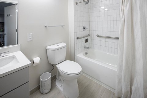 A white toilet sits next to a white sink in a bathroom.