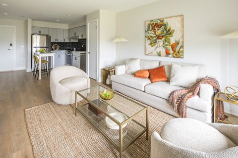 A modern living room with a white couch and a glass coffee table.