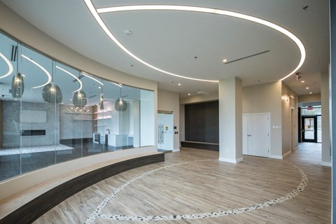 A modern interior with a curved wooden floor and a glass wall.
