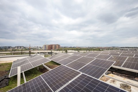 A large solar panel farm with a cloudy sky in the background.