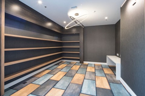 A room with a long row of shelves and a colorful floor.