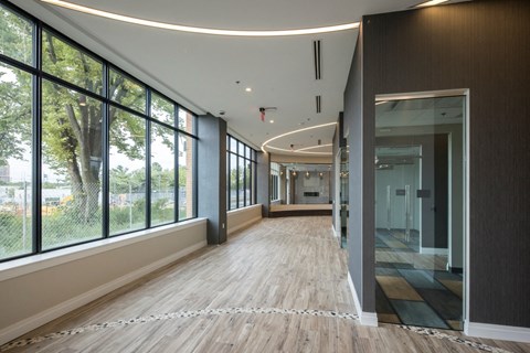 A long hallway with wood floors and windows on one side.