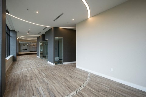 A long hallway with wood floors and white walls.