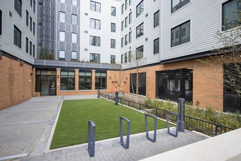 A modern building with a brick facade and a green lawn in front.