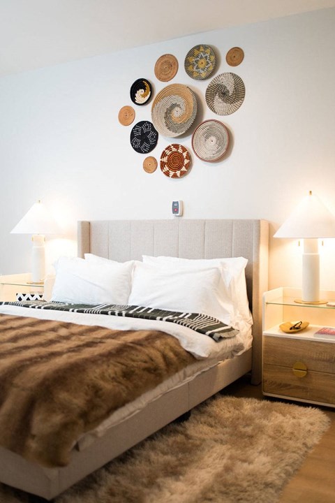 a bedroom with a bed and plates on the wall above it