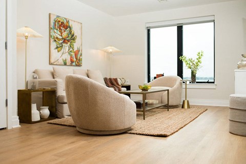 a living room with white furniture and a large window