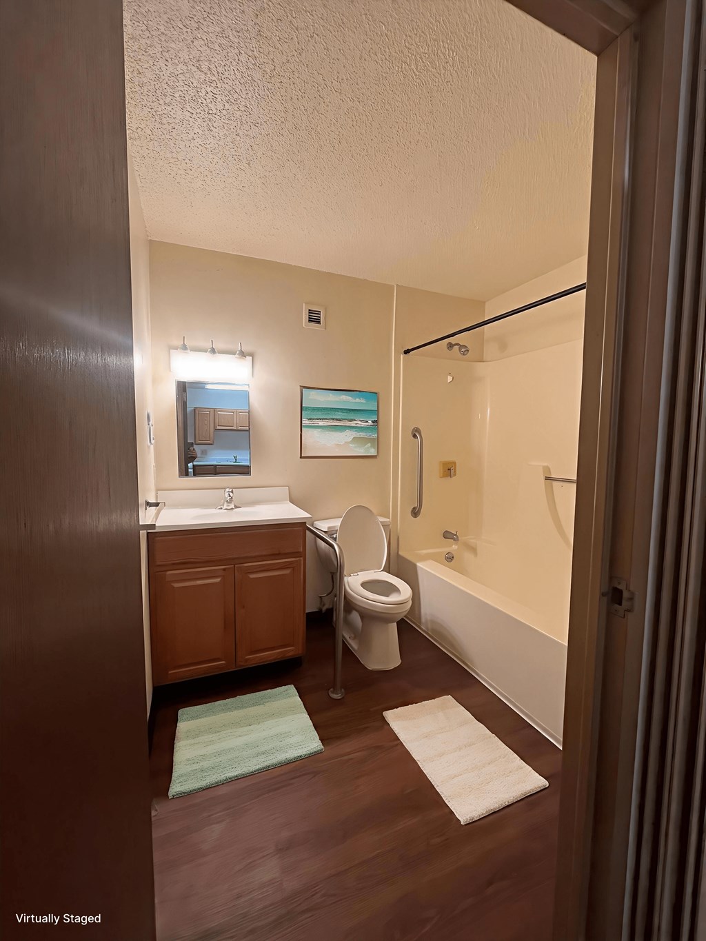 A bathroom with a toilet, sink, and mirror.