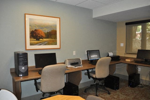 two computers sitting on desks in an office