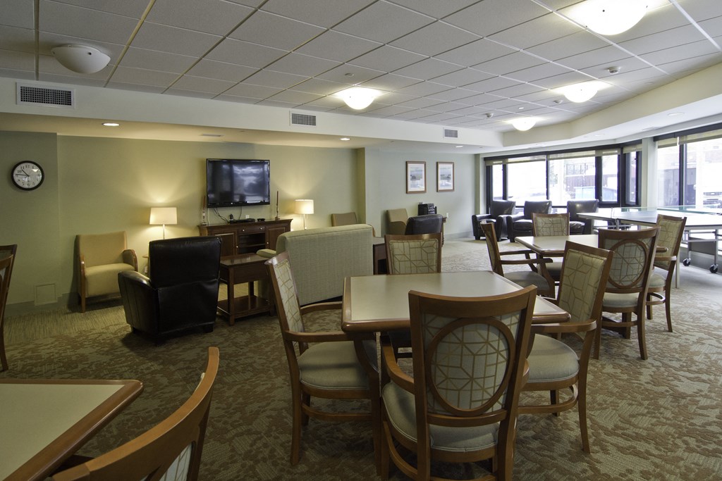 a large room with tables and chairs and a television