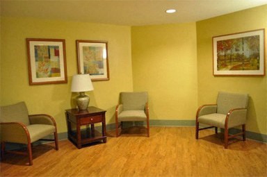 a living room with chairs and paintings on the wall