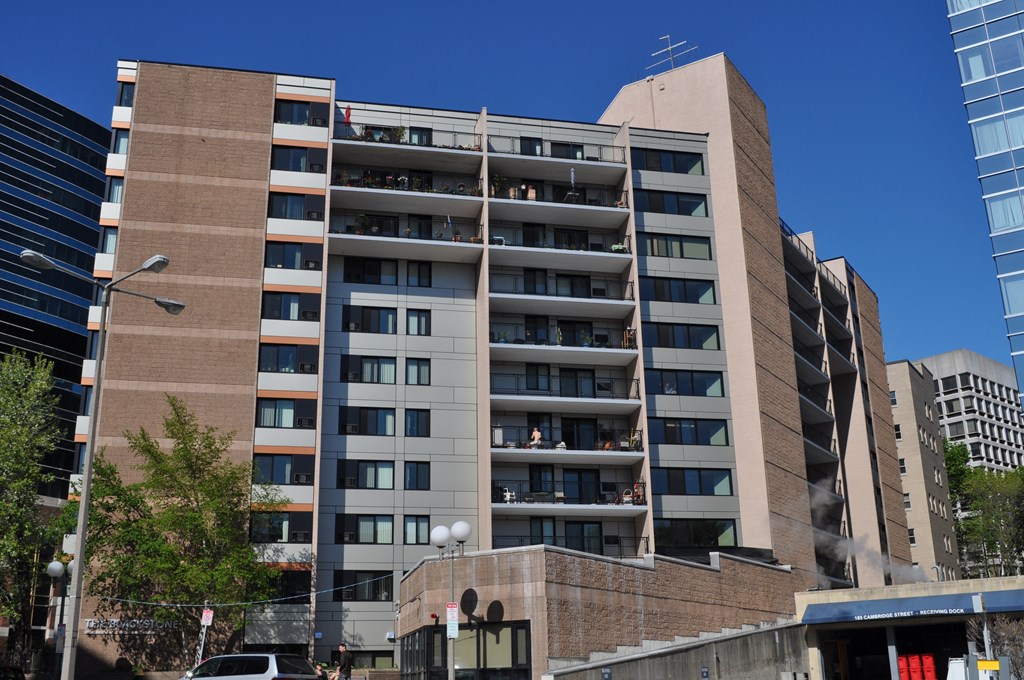 an image of a tall building with balconies in a city