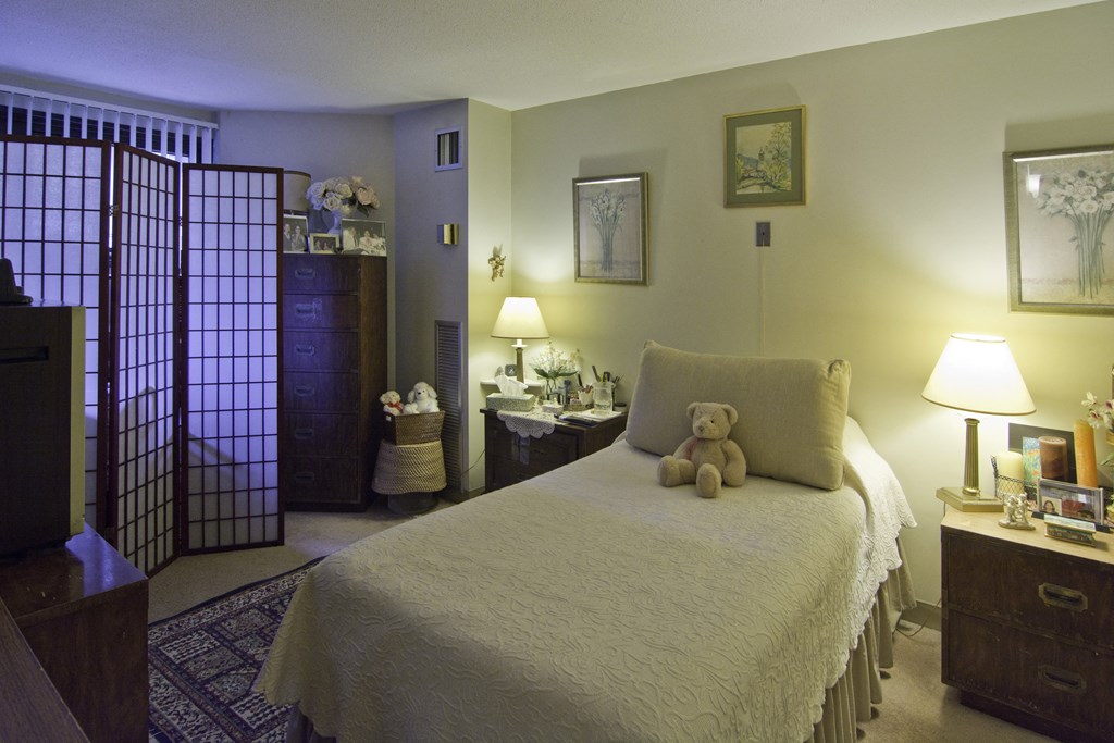 a bedroom with a bed and a teddy bear