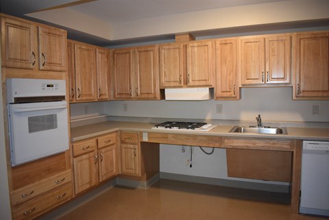 A kitchen with wooden cabinets and a white fridge.