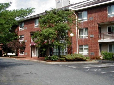 a red brick apartment building with a parking lot