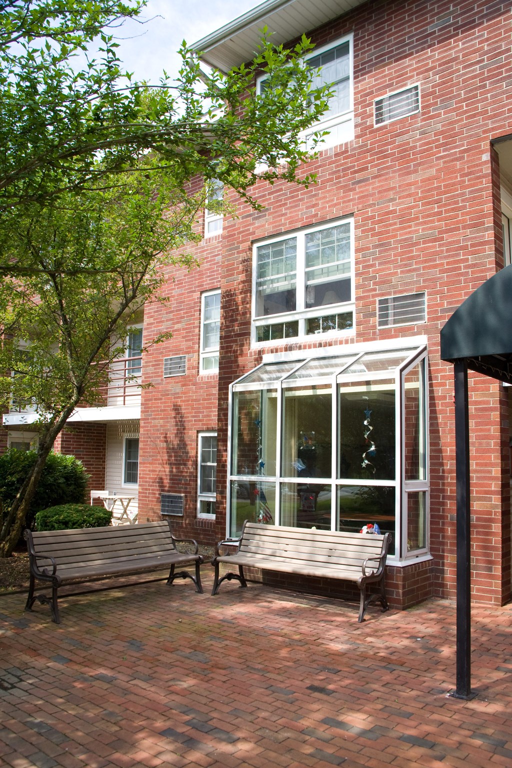 two benches in front of a brick building with a window