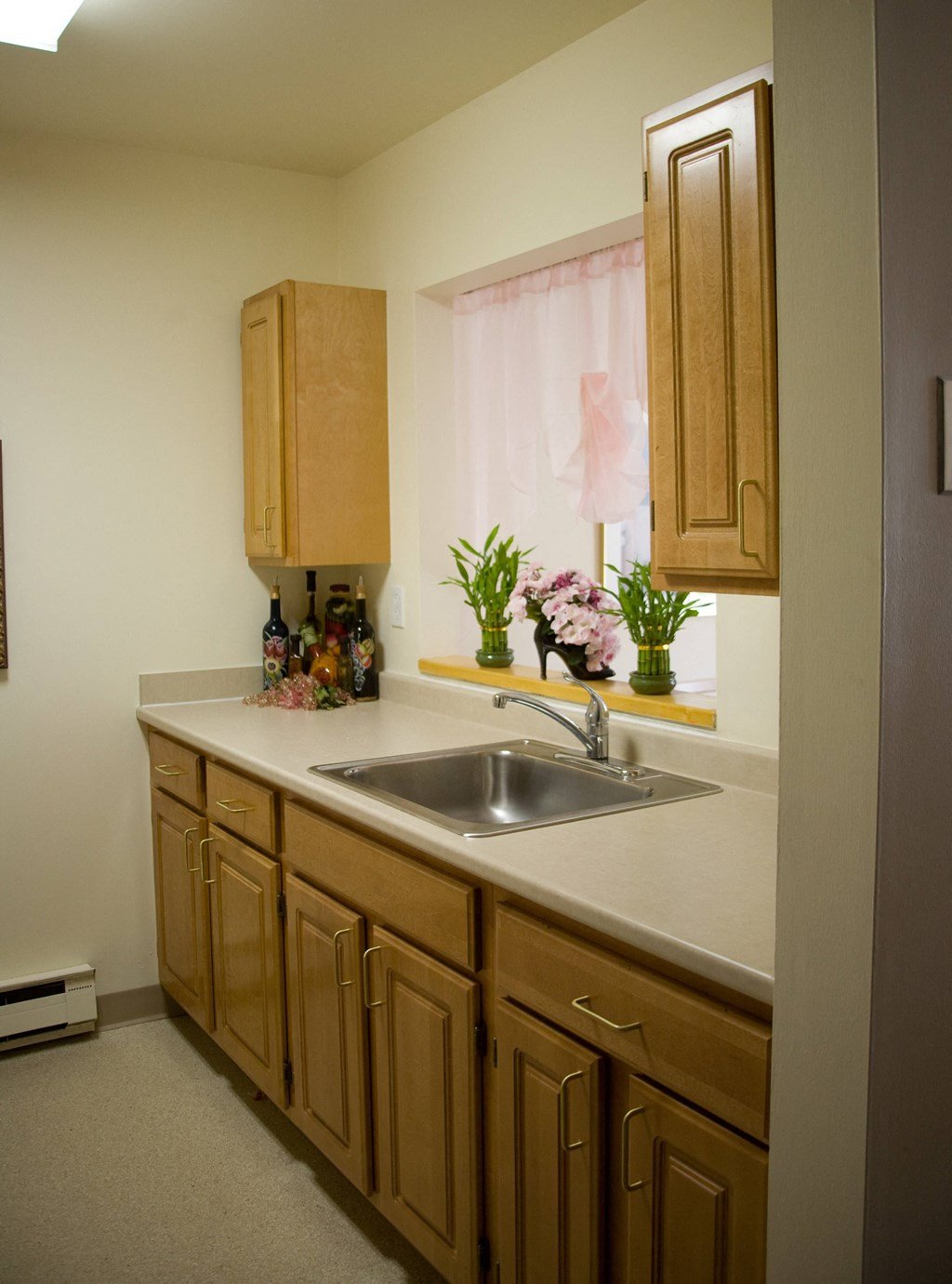 a small kitchen with a sink and wooden cabinets