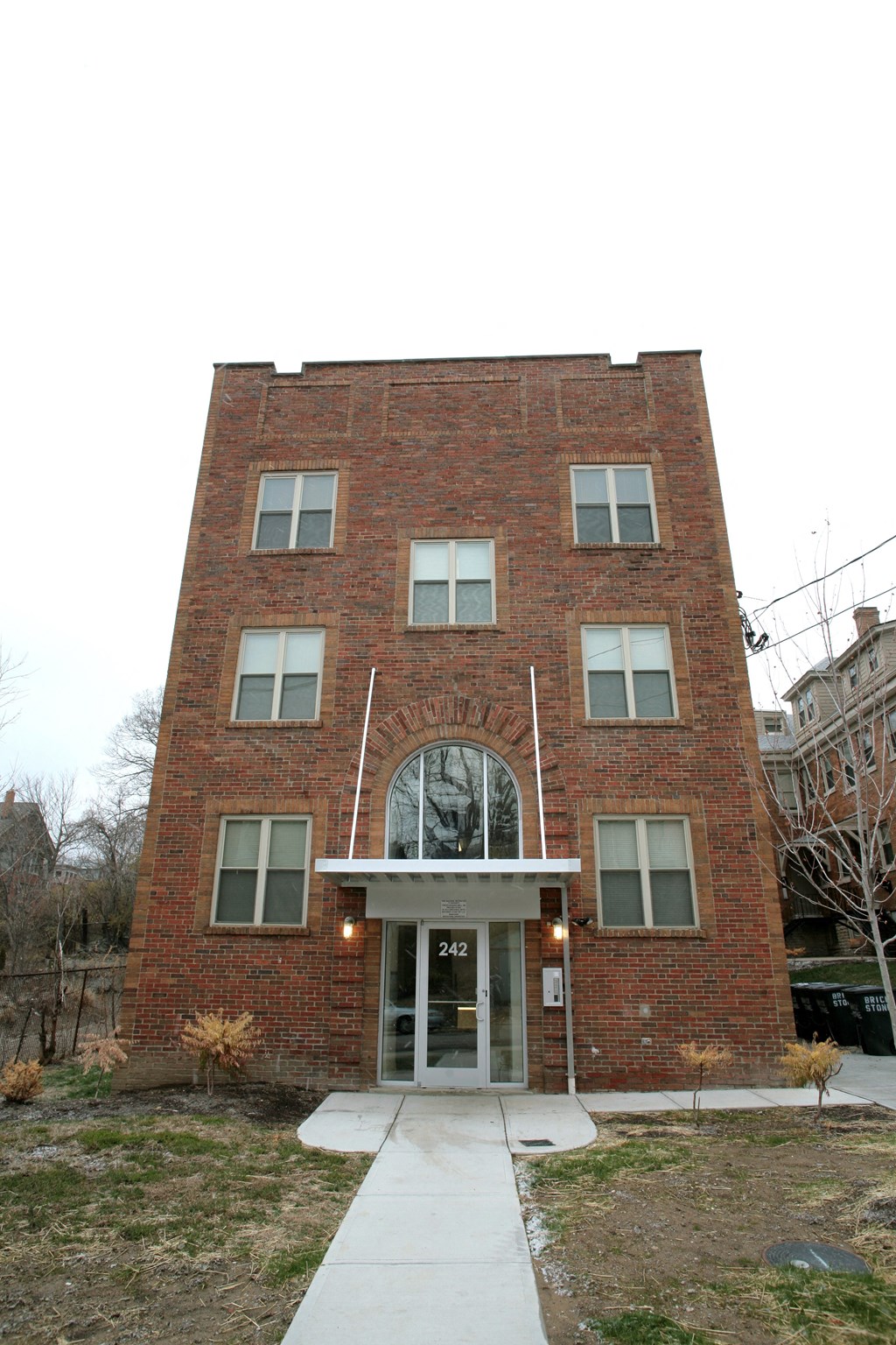 the front of a brick building with a sidewalk in front