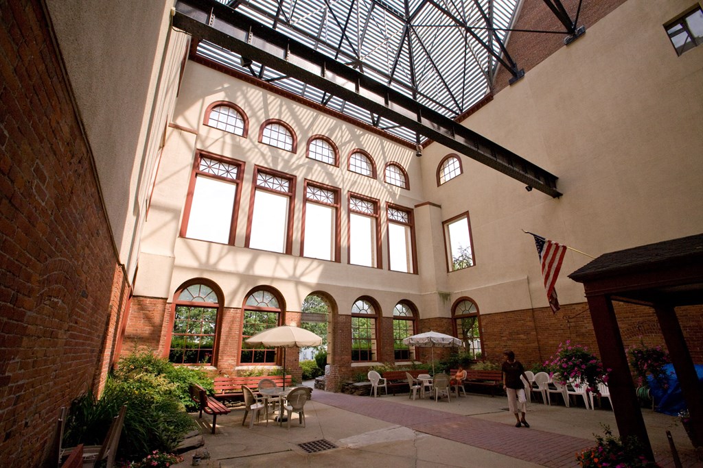 a large building with a glass ceiling and a courtyard with tables and chairs