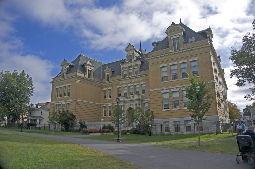 a large brick building on the side of a sidewalk