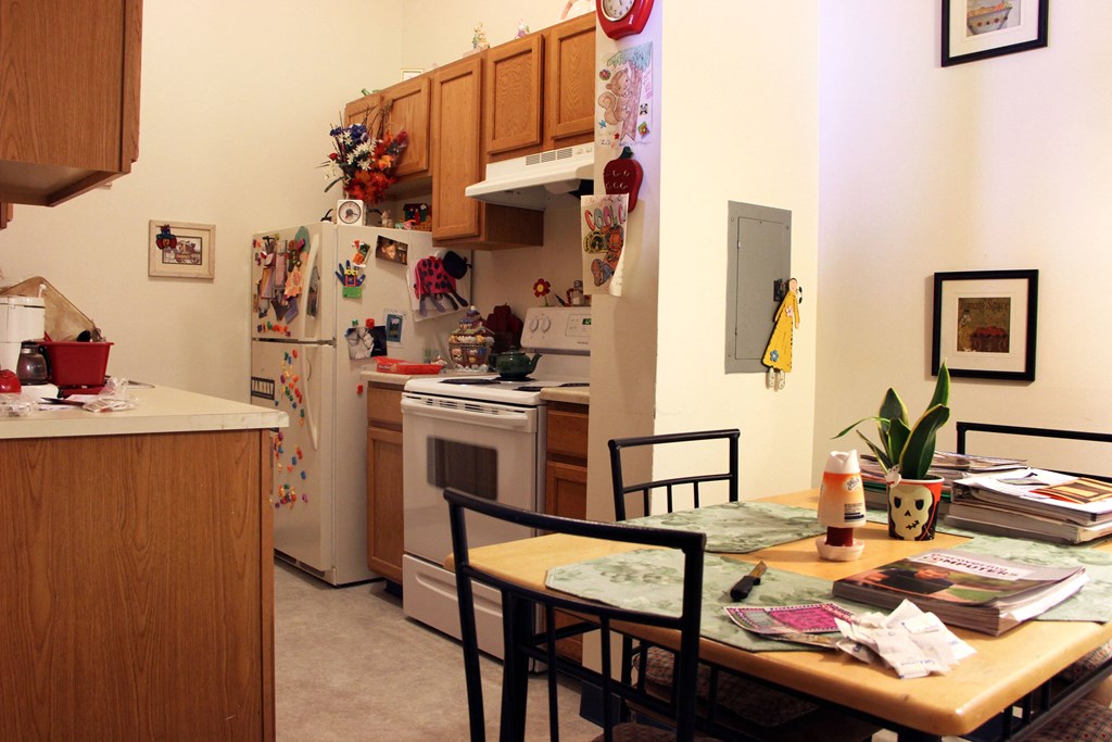 the kitchen and dining area of a small apartment with a table and chairs