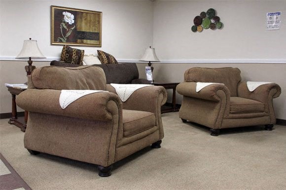 a living room with three chairs and a table