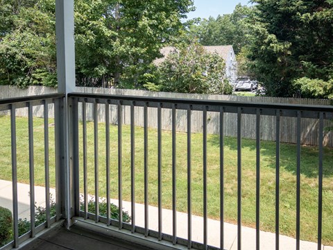 A metal railing overlooks a green lawn.