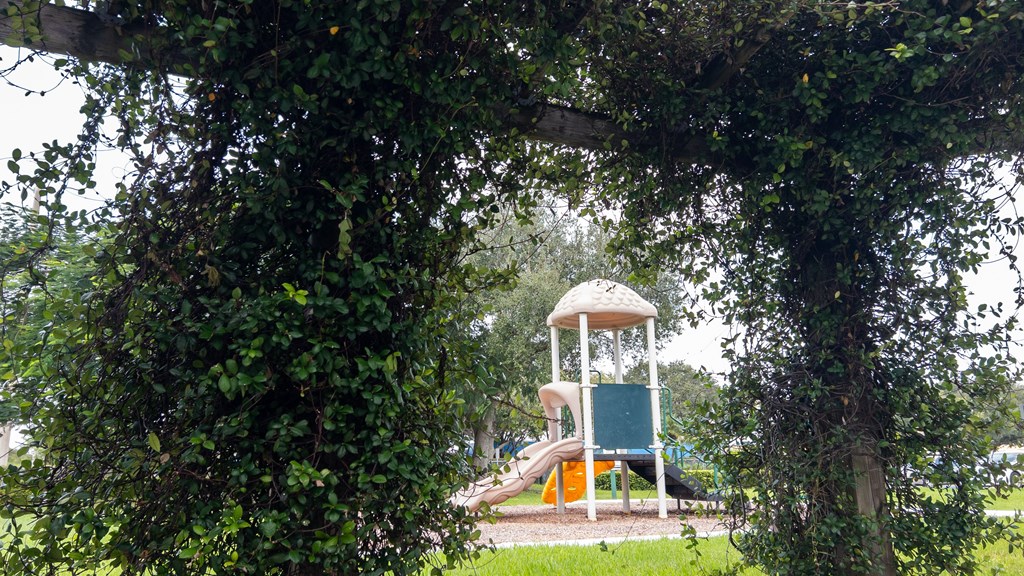 A playground with a green slide and a white tower.