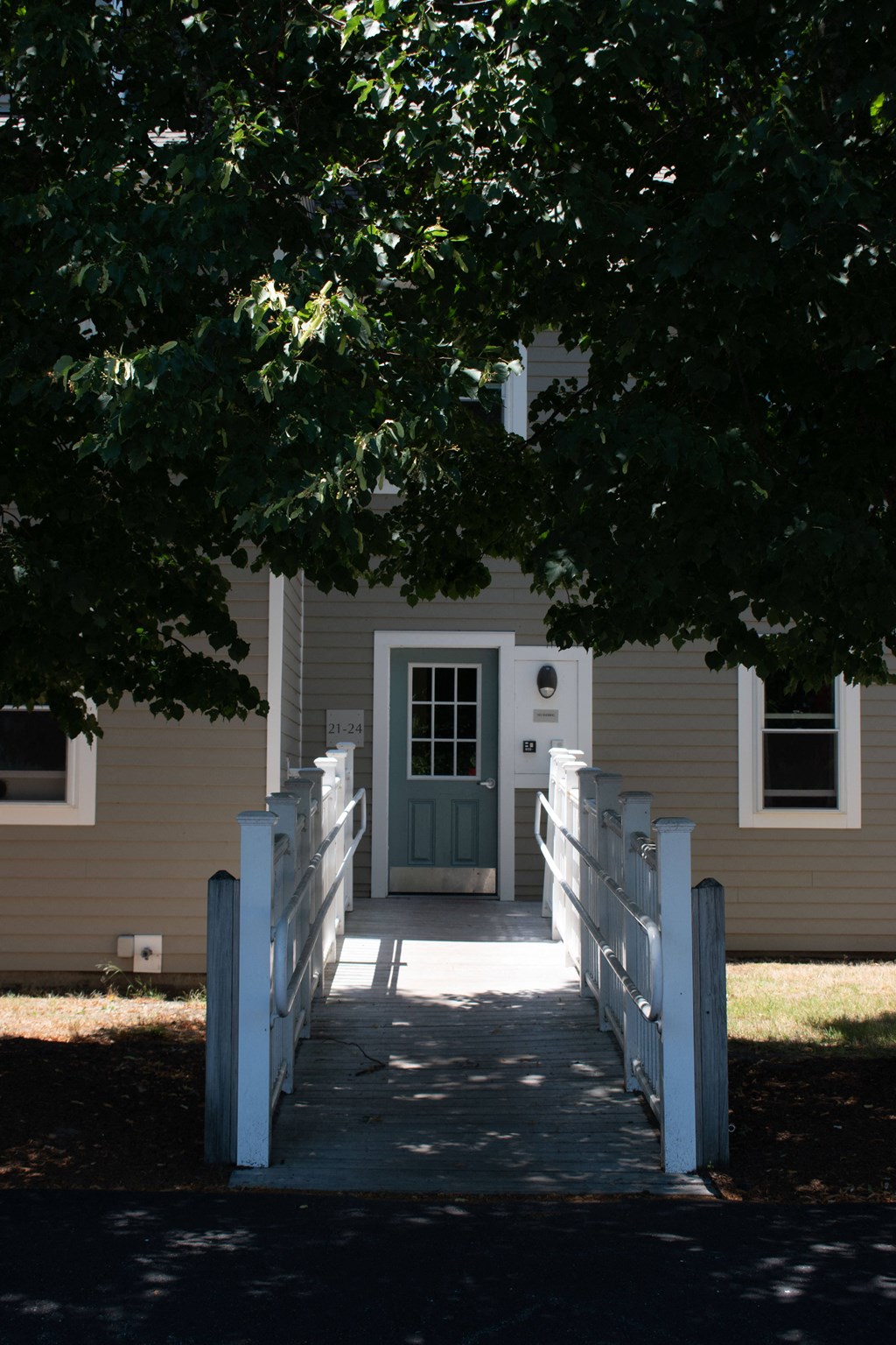 a white house with a white walkway and a green door