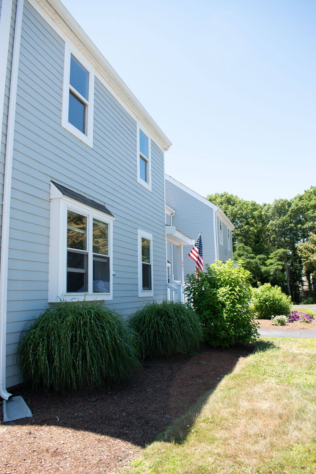 a blue house with an flag in the front yard