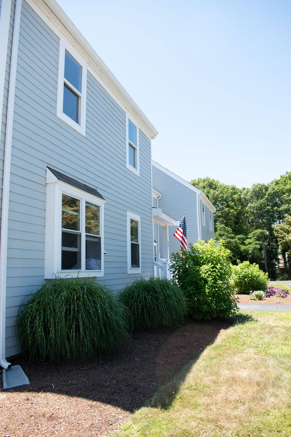 a blue house with an flag in the front yard