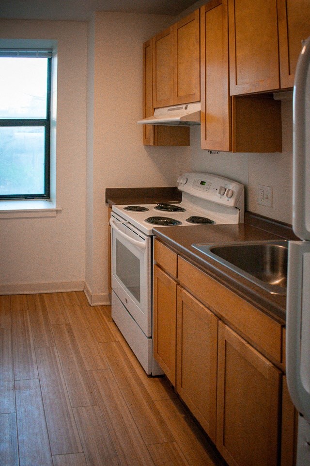 an empty kitchen with a stove and a sink