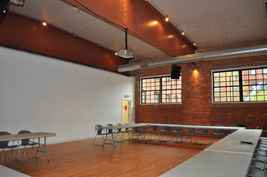 a large room with tables and chairs and a projector