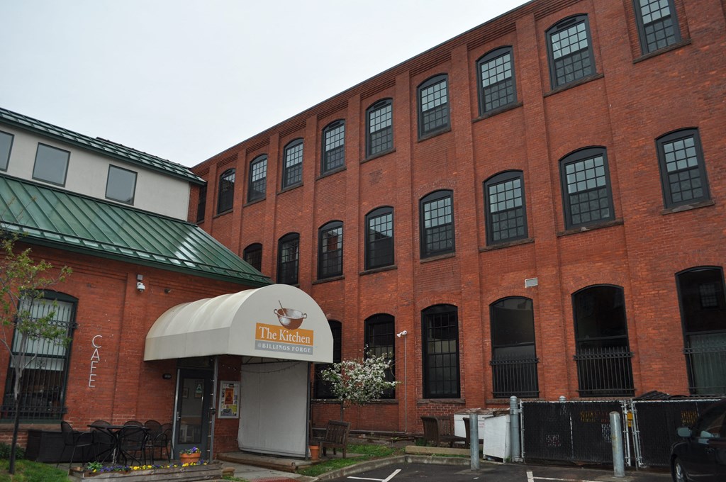 a red brick building with a sign in front of it