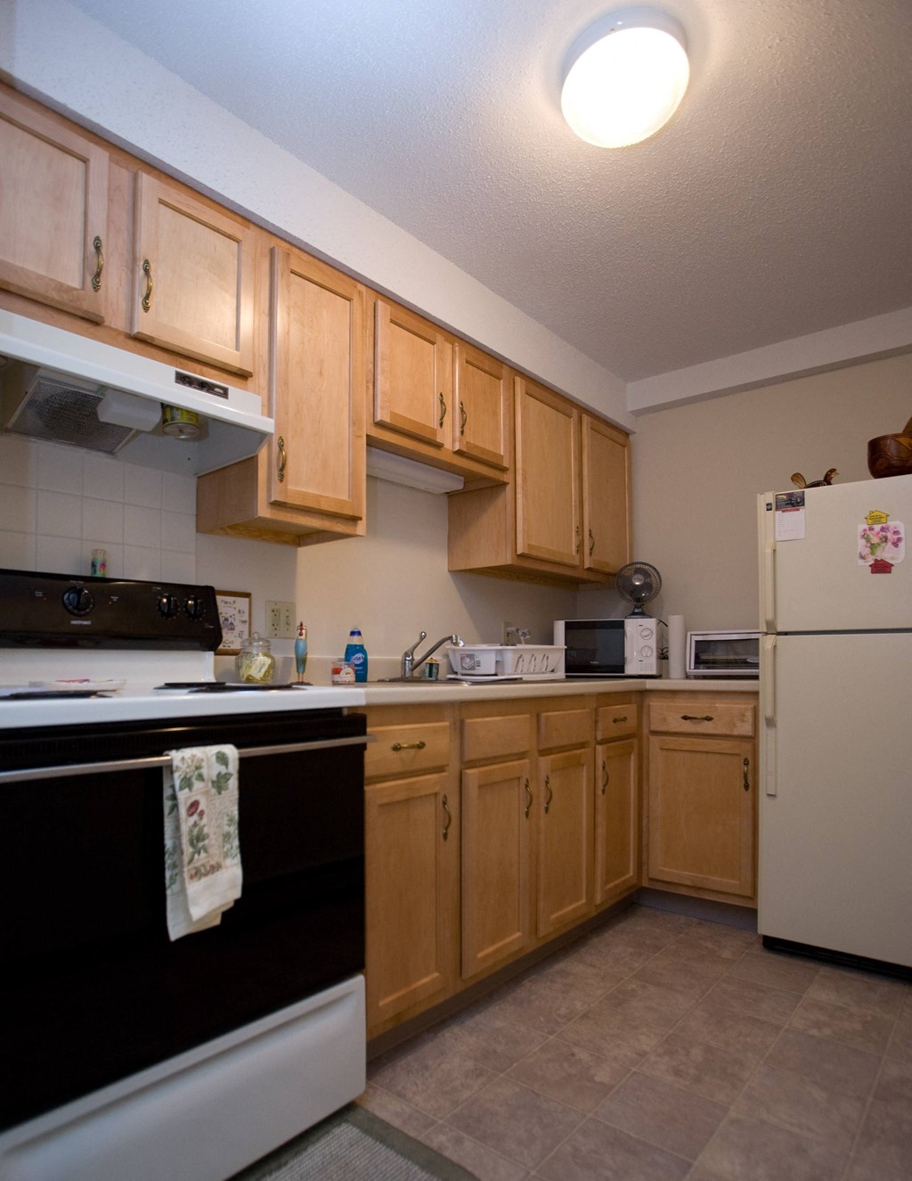 a kitchen with white appliances and wooden cabinets