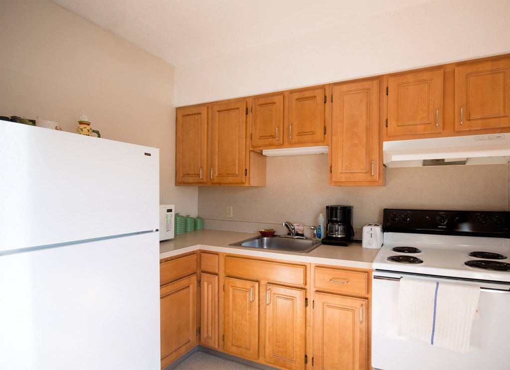a kitchen with white appliances and wooden cabinets