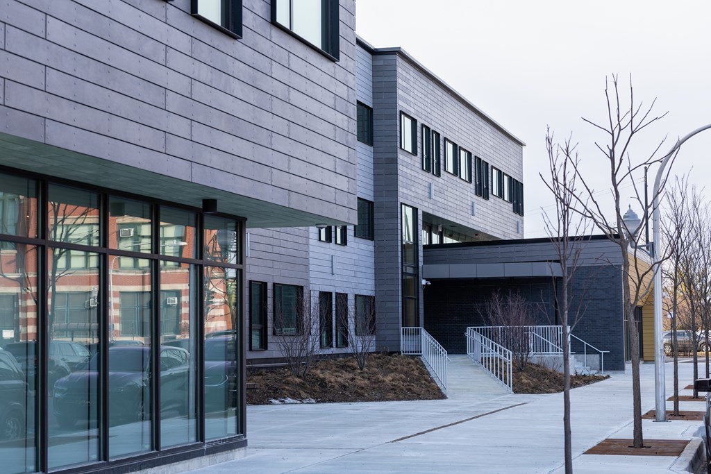 A modern building with a grey exterior and a glass entrance.
