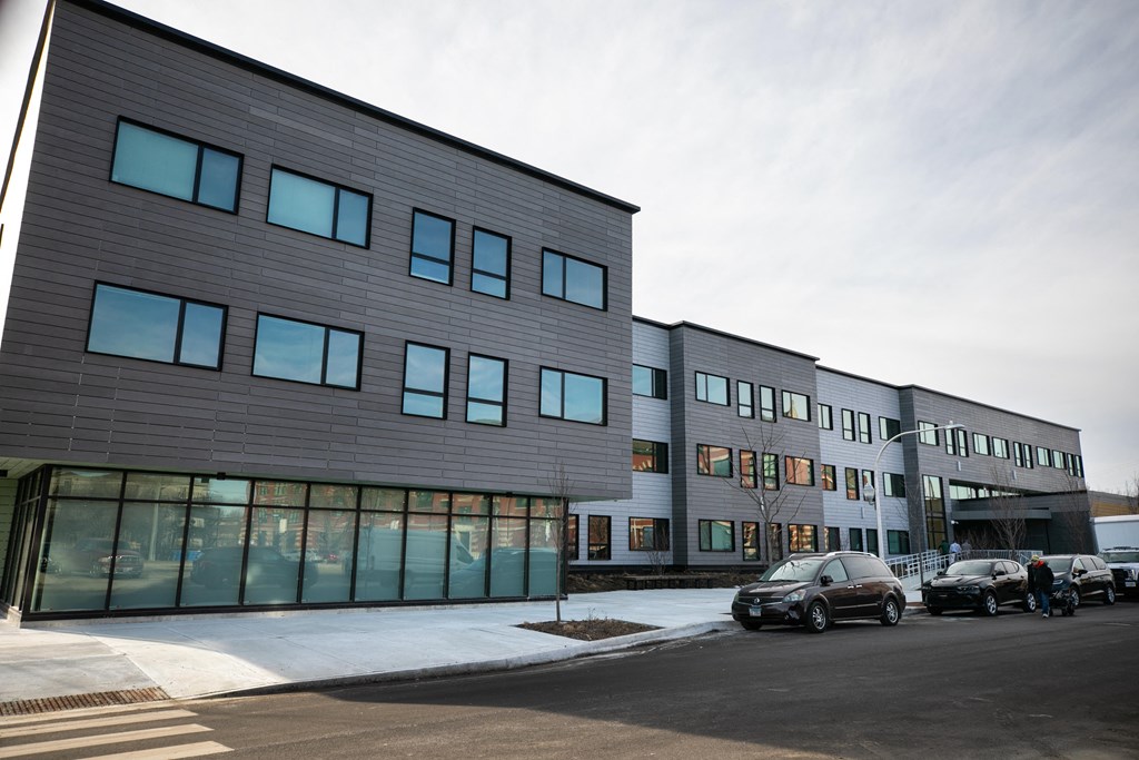 A modern building with a parking lot in front.