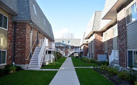 A long white pathway leads between two rows of houses.