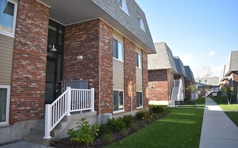 A row of houses with a white picket fence in front.