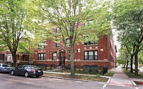 a red brick building with cars parked in front of it