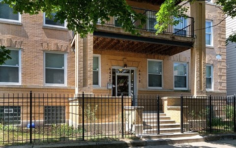 a brick house with a black fence in front of it