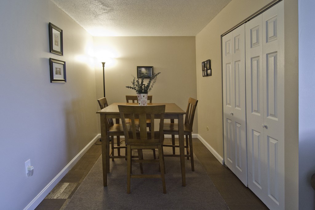an empty dining room with a wooden table and chairs