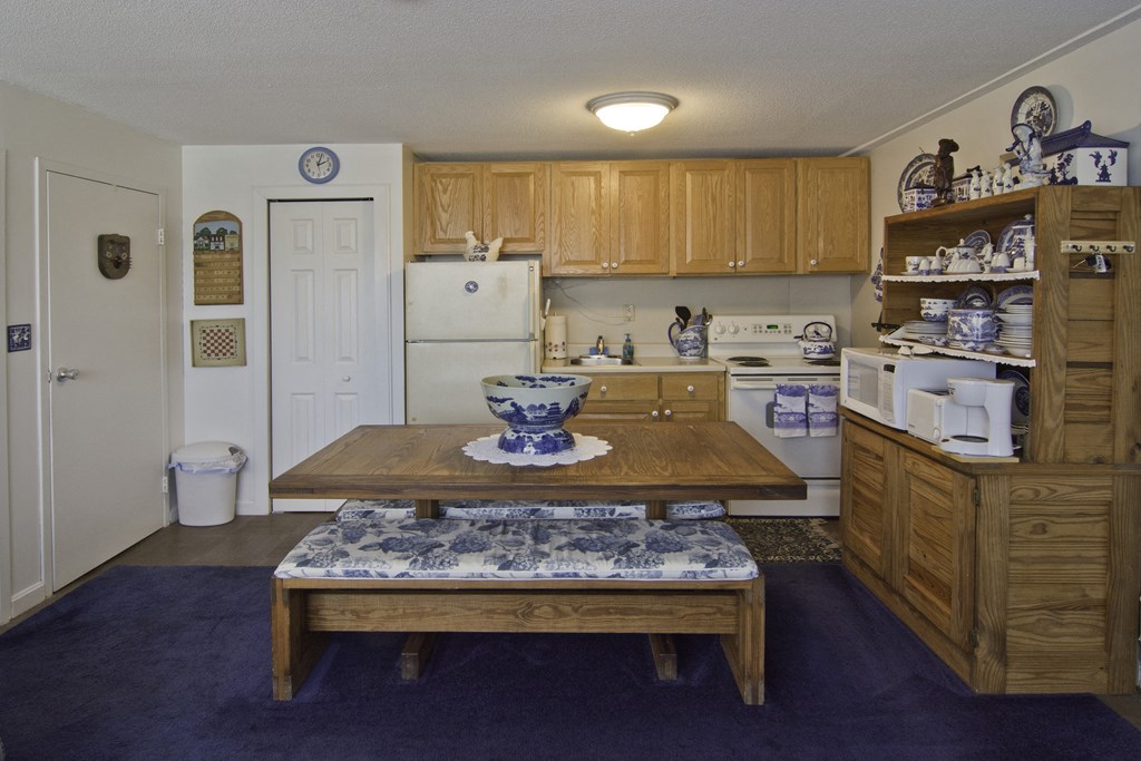 a kitchen with a wooden table and a white refrigerator