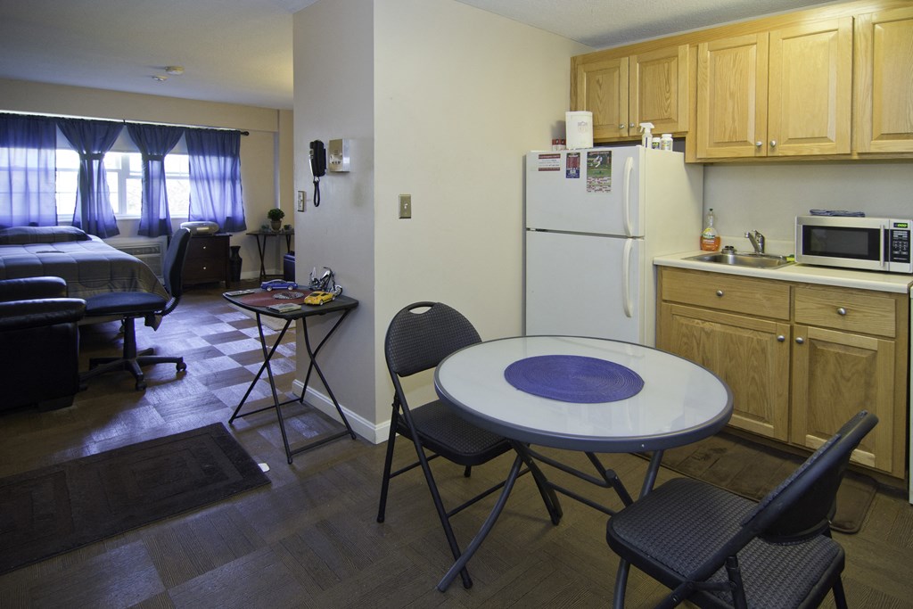 a kitchen and dining room with a table and chairs and a refrigerator