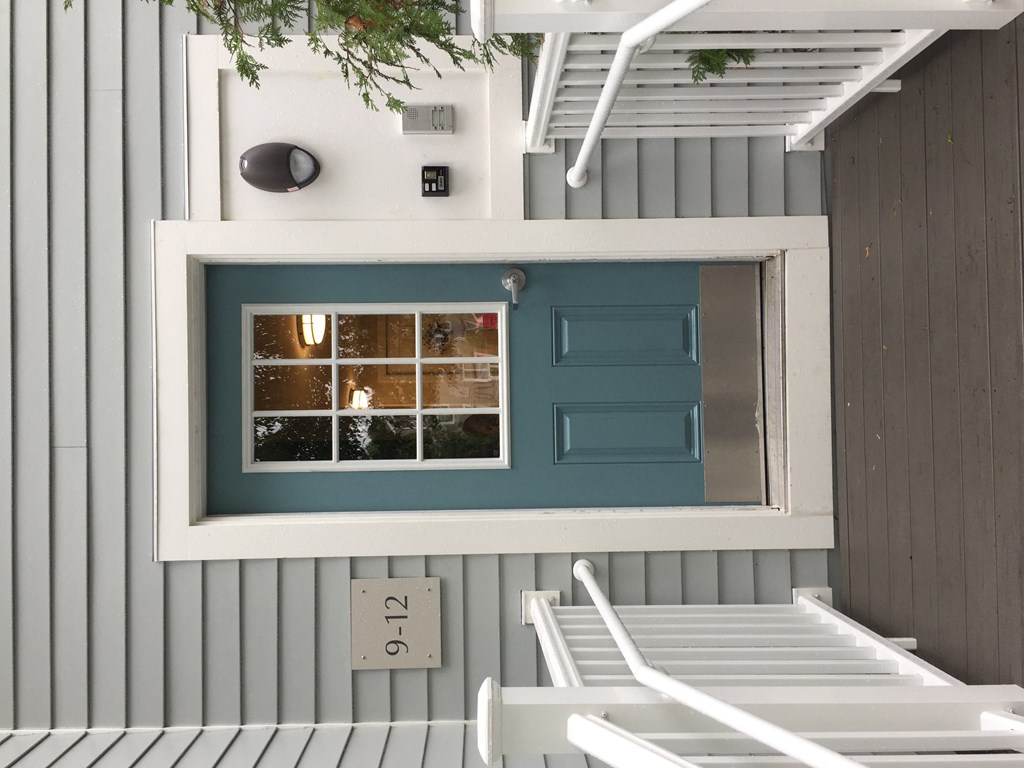a tiny house with a blue door and a staircase
