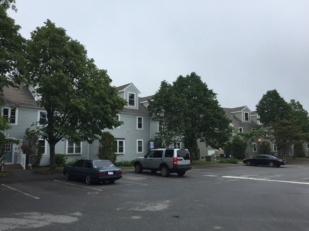 a parking lot with cars in front of houses