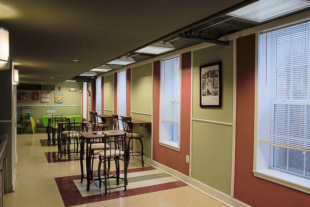 a dining area with tables and chairs in a room with windows