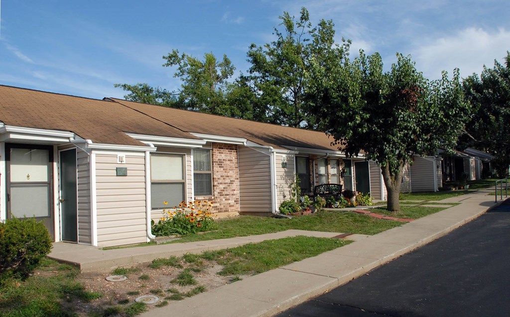 a home in a neighborhood with a sidewalk and a tree